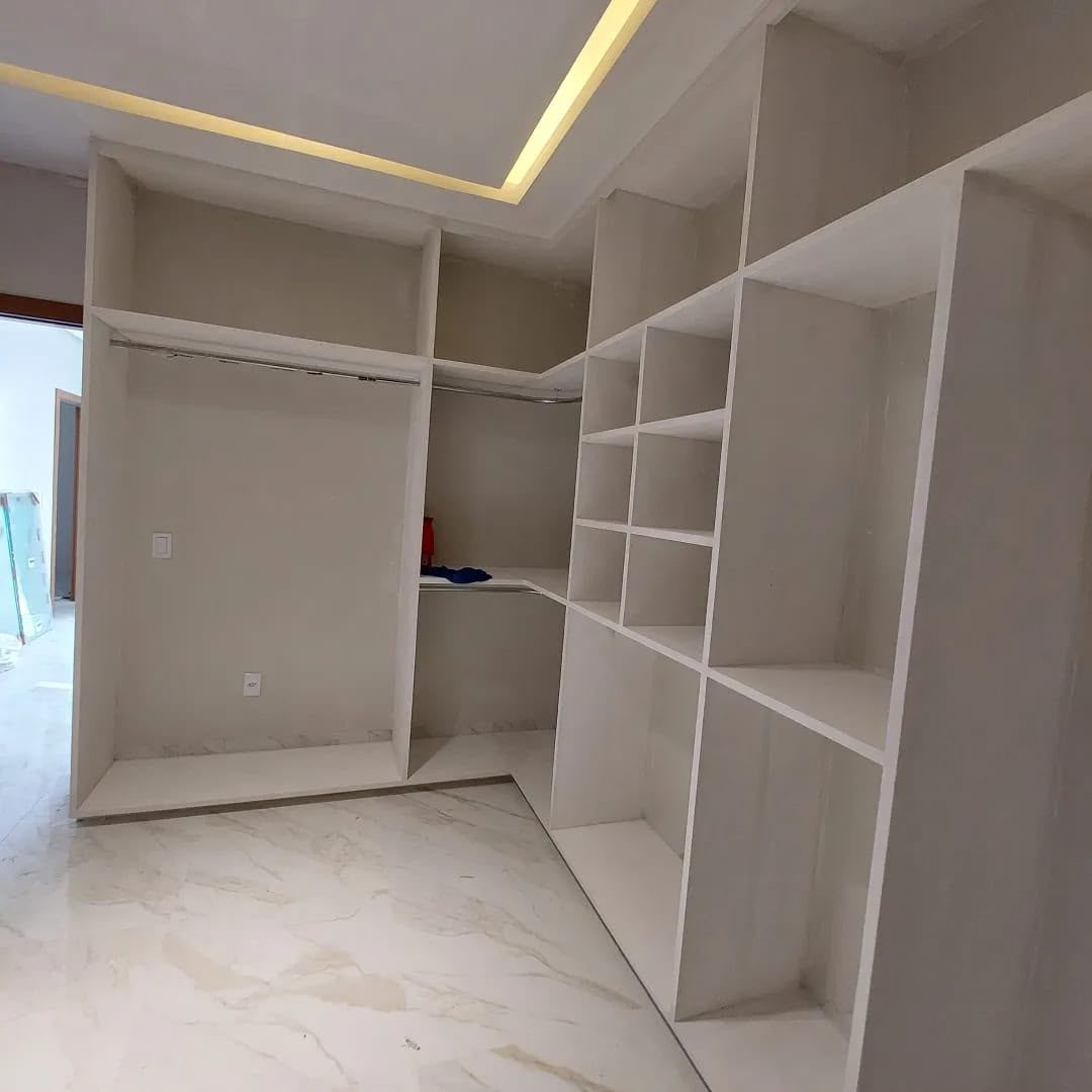 Closet planejado em gesso com iluminação embutida e piso em porcelanato
