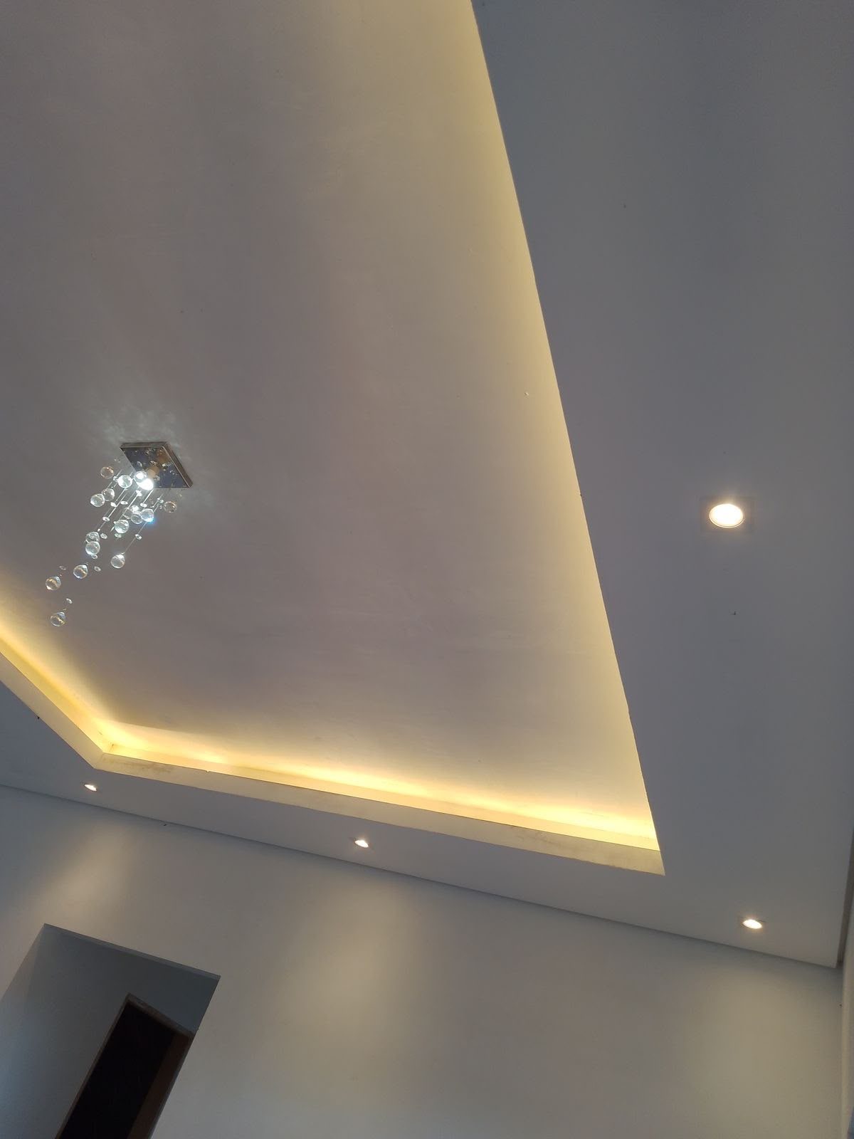 Forro de gesso com sanca e iluminação indireta em pé-direito alto