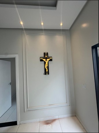 Painel de parede em gesso com moldura decorativa e detalhe de iluminação